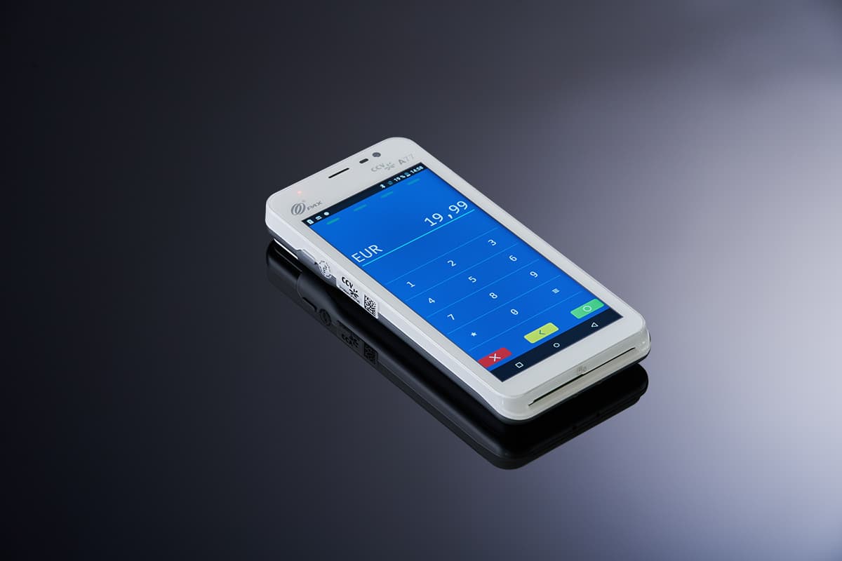 Kompaktes weißes Kartenterminal mit Touchdisplay und Betrag in Euro vor dunklem Hintergrund.