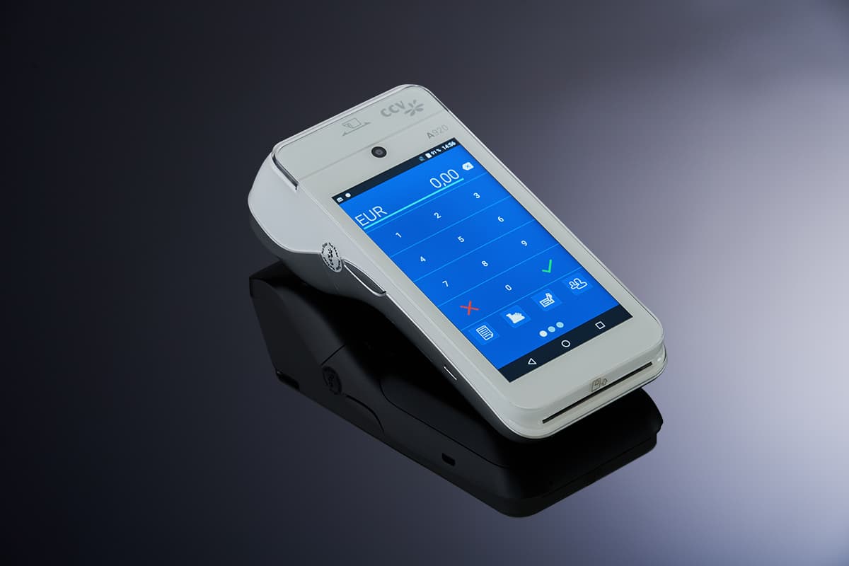 Mobiles Kartenterminal mit weißem Gehäuse und blauem Eingabedisplay vor dunklem Hintergrund.