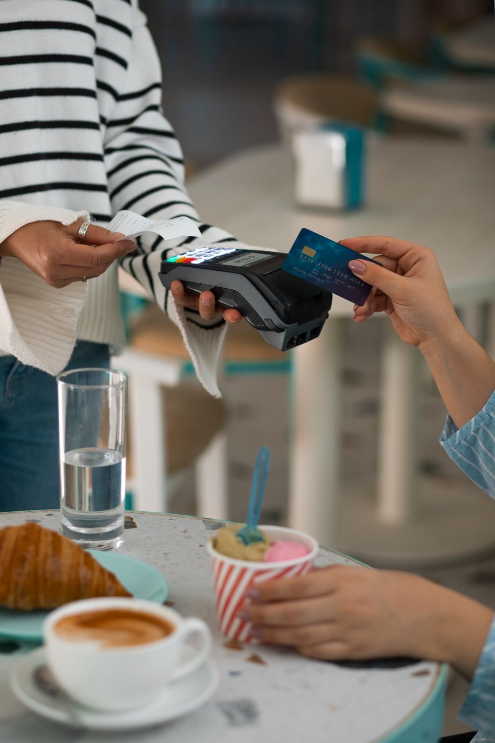 Kunde bezahlt kontaktlos per Smartphone am Kartenterminal